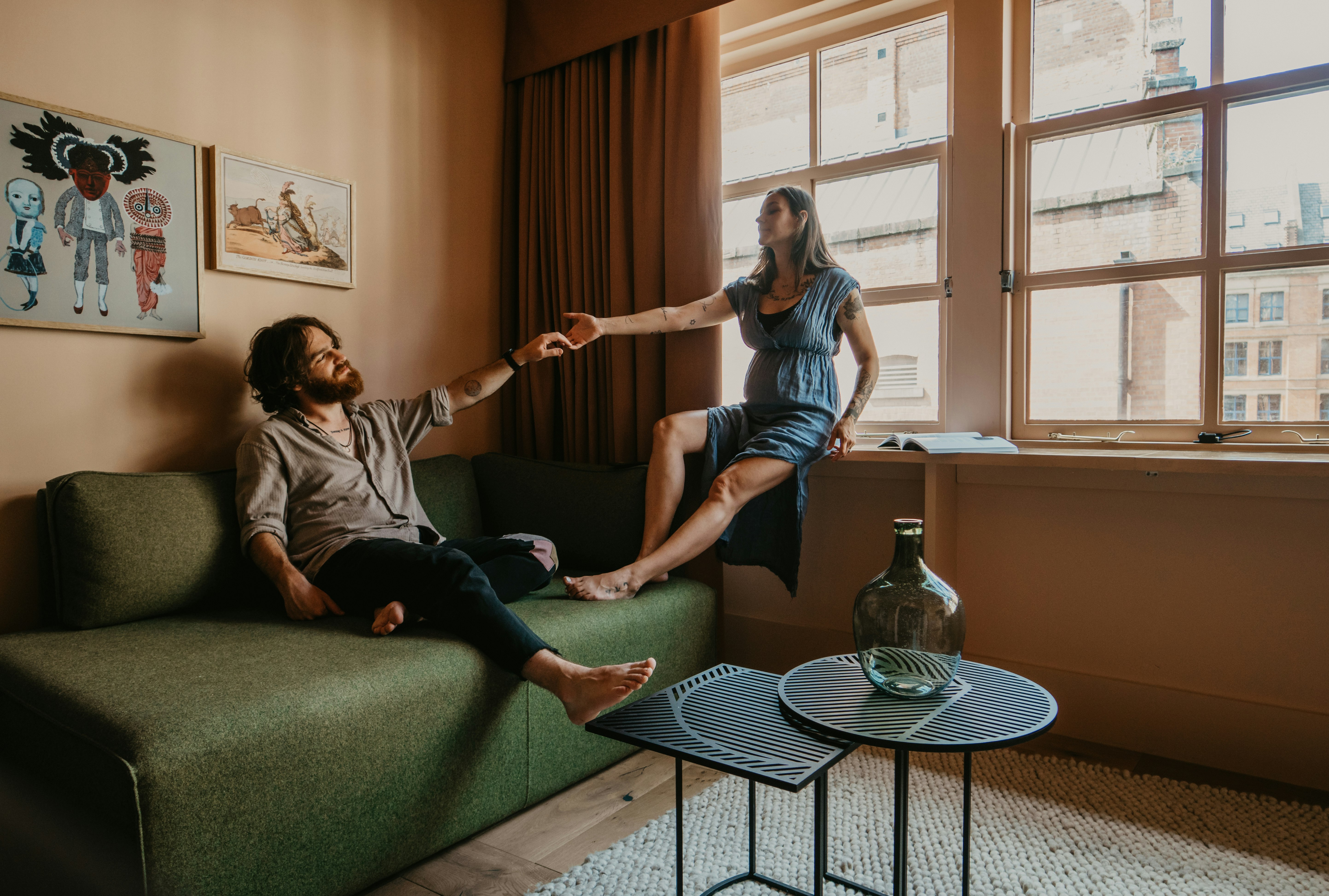 woman in gray long sleeve shirt and black pants sitting on black and white checkered couch